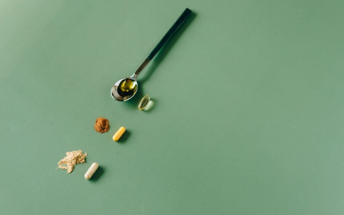 Suplementos e pós fitoterápicos variados em fundo verde com uma colher