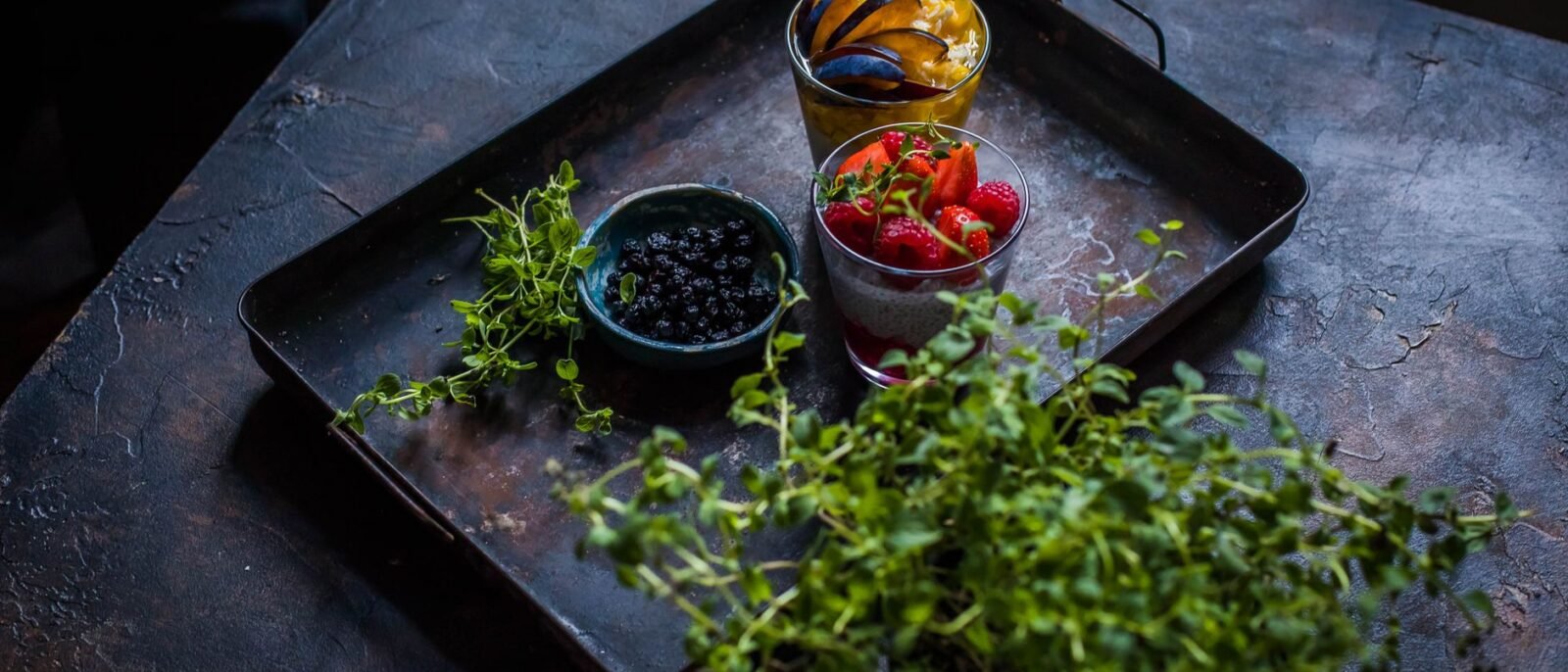 Frutas frescas com ervas em uma bandeja rústica, perfeitas para uma alimentação saudável