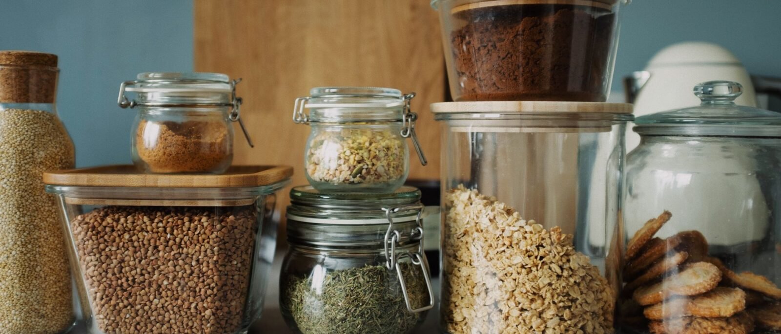Dispensa elegante com variedade de alimentos em potes de vidro, exibindo secos e biscoitos