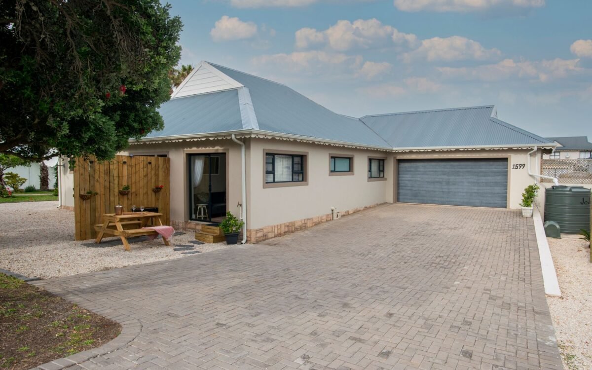 Uma casa suburbana moderna com garagem ampla e área externa aconchegante para sentar